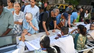 Maharashtra Civic Body Elections Updates: People searching for their name in the voter list outside the Polling station in Dadar, Mumbai.